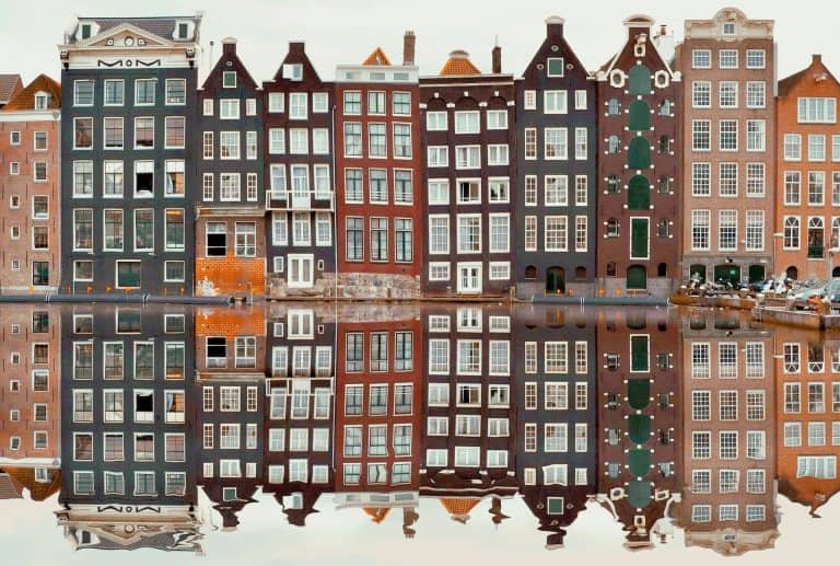 Discover Amsterdam: Self-Guided Walking Tour of Dutch Resistance Sites 48 Amsterdam buildings reflected on a canal.